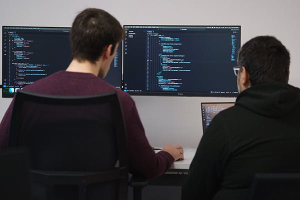Two people pair programming in an office