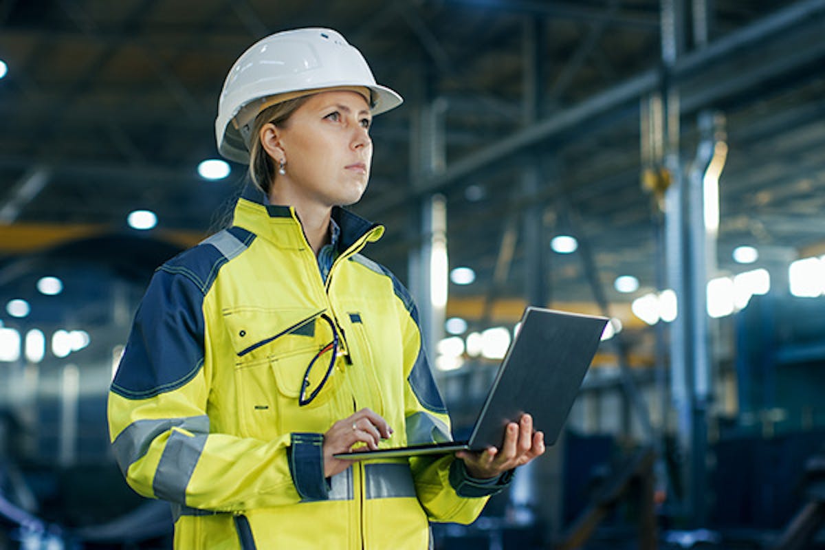 Woman holding a laptop in a factory