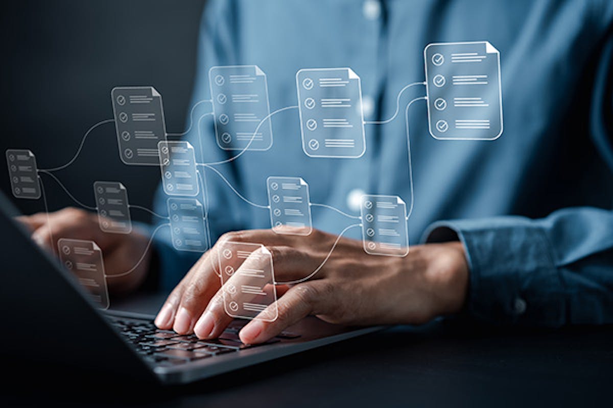 Person using a laptop keyboard with an overlay of interconnected documents