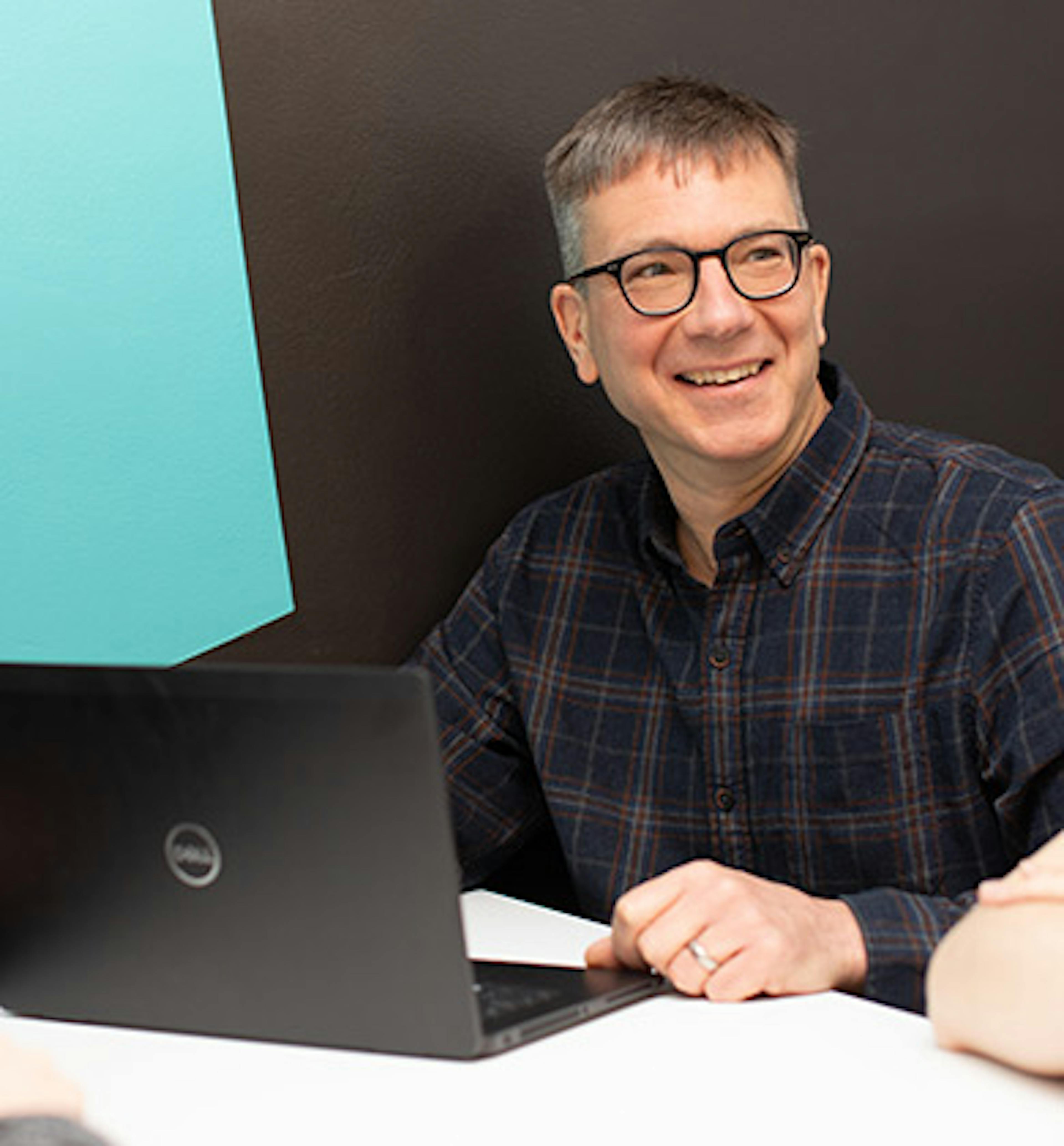 Man in a meeting using a laptop