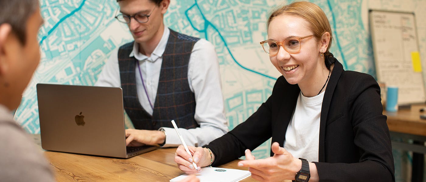 Three people having a meeting around a table