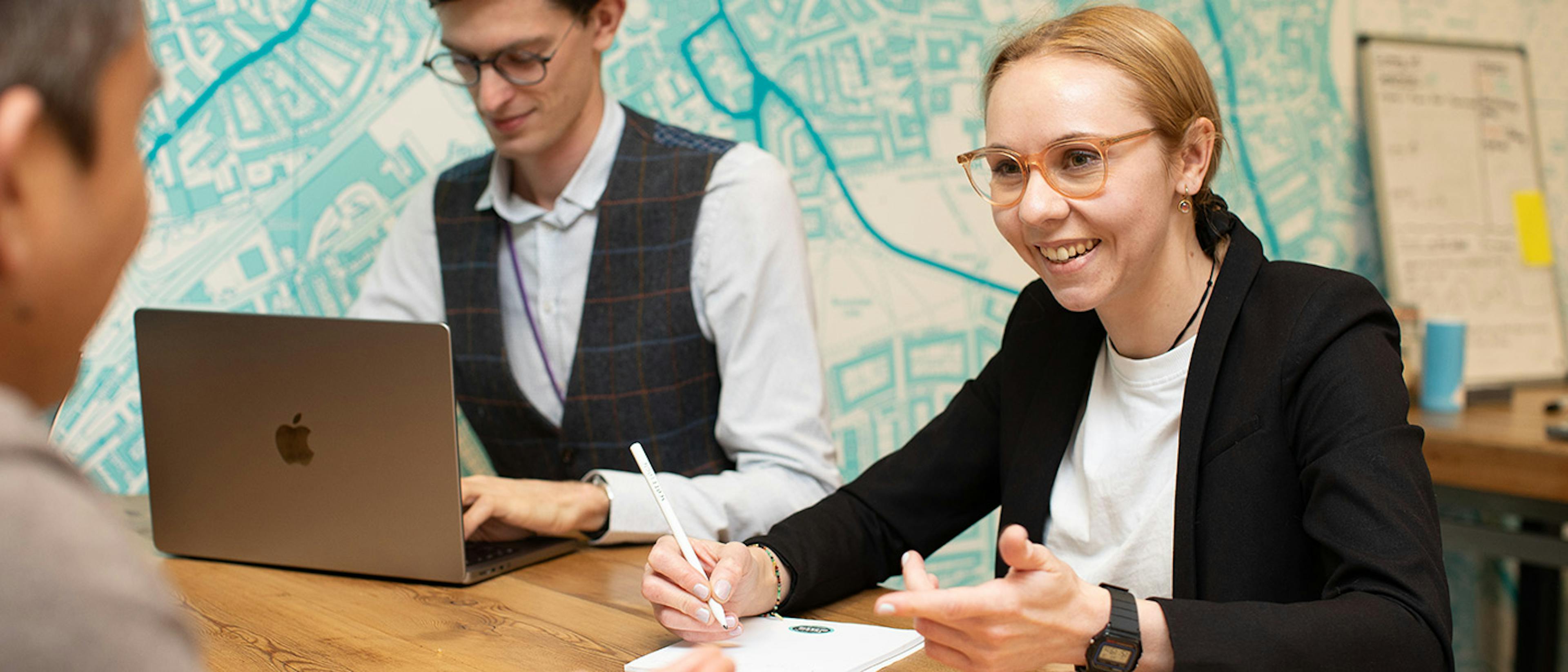 Three people having a meeting around a table