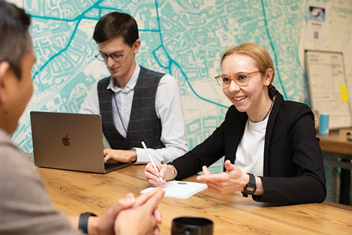 Three people having a meeting around a table