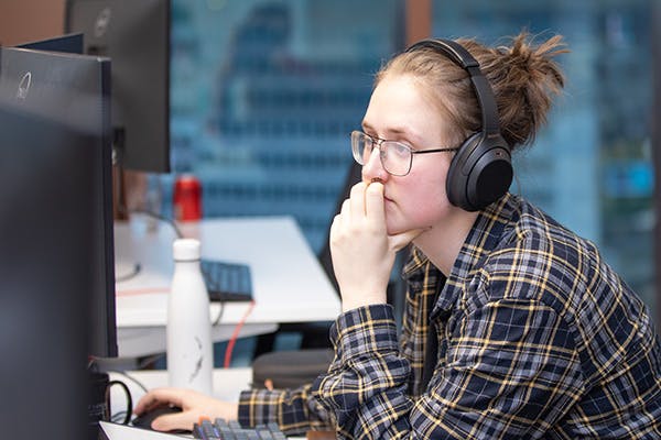 Person wearing headphones while working on a computer