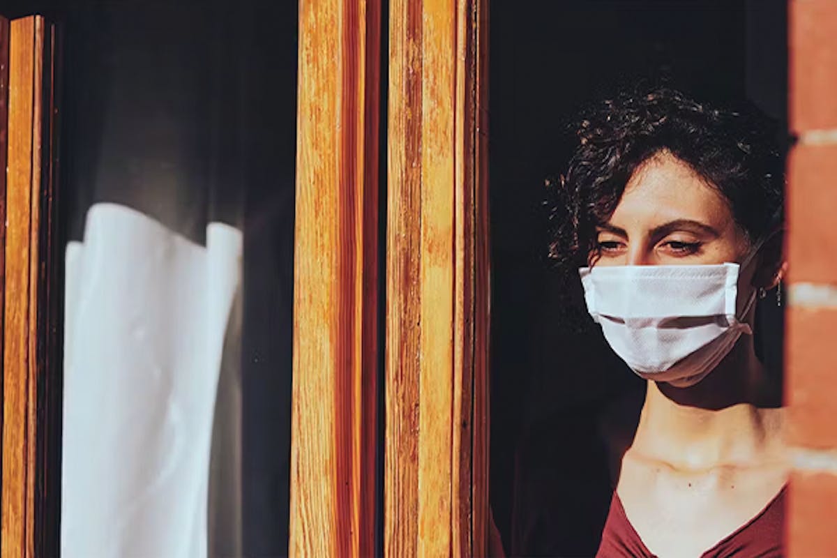 Woman wearing a face mask, sheltering during the COVID-19 pandemic