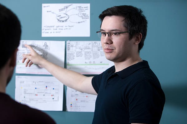 Person presenting some sketches on a wall