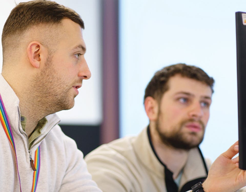 Two people in discussion at a computer monitor
