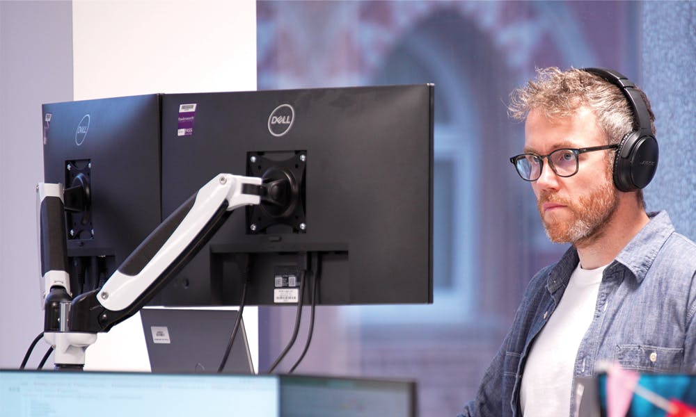 Person wearing headphones looking at computer monitor
