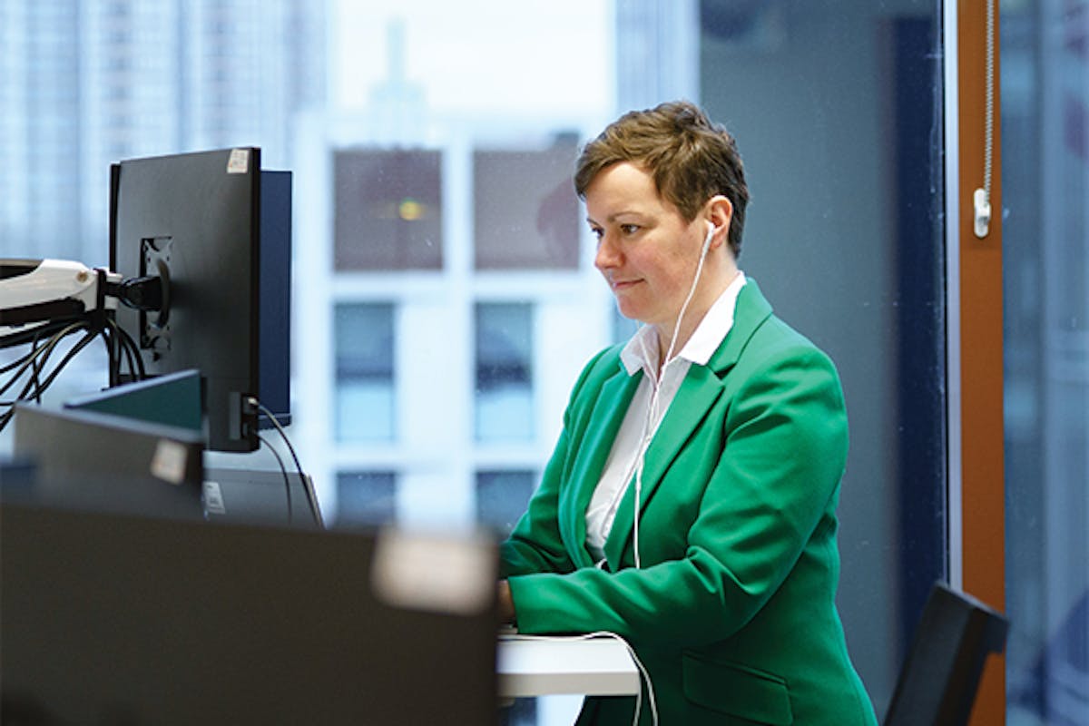 Person working on a computer at a standing desk
