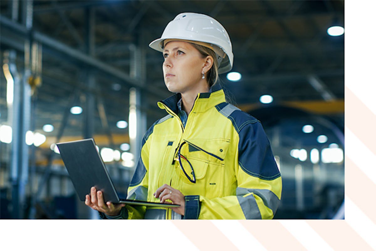 Woman holding a laptop in a factory