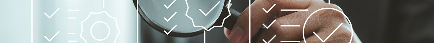 Person holds up magnifying glass to outlines of checklists