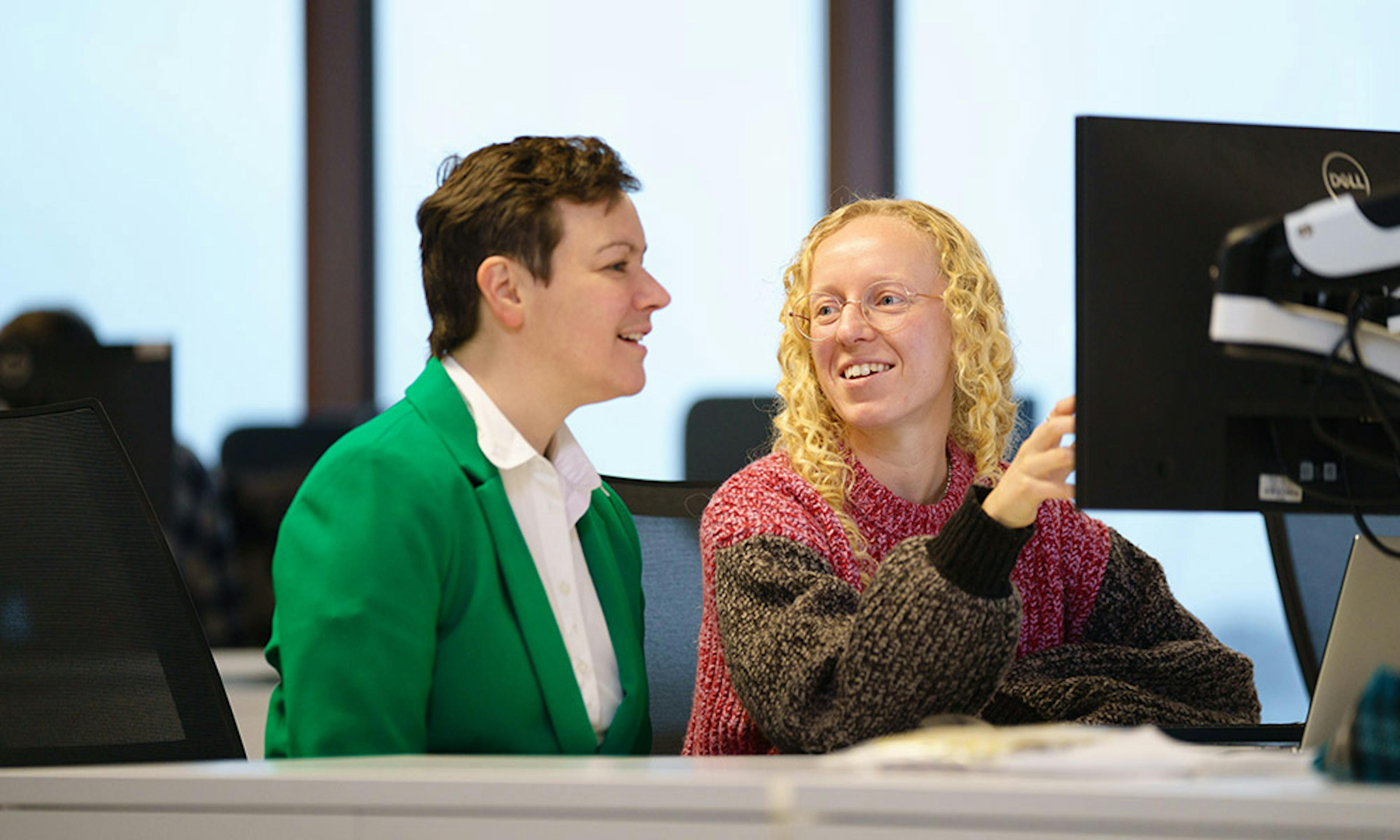 Two people talking about some code on a screen