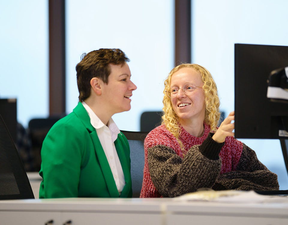 Two people talking about some code on a screen