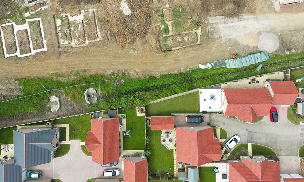 Aerial shot of a housing development, showing new-build houses and new plots being readied for development