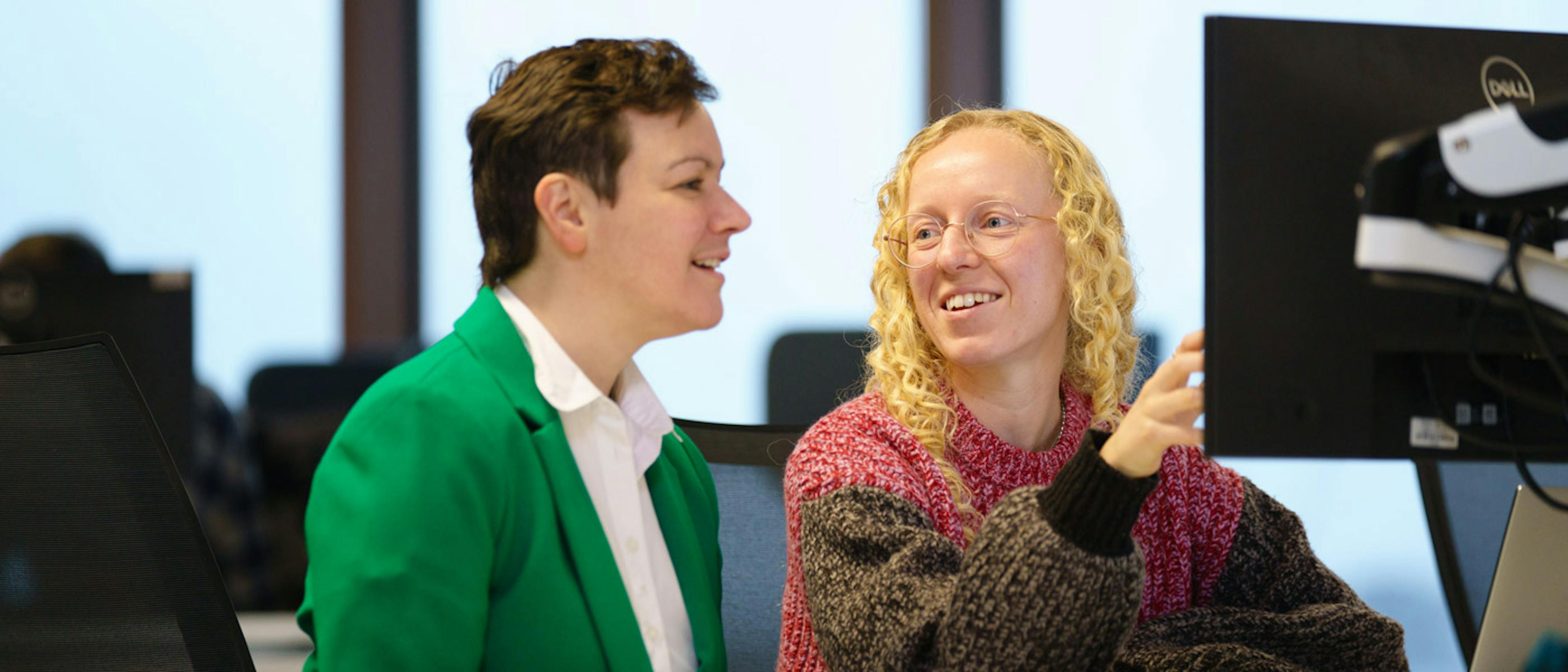Two people talking about some code on a screen