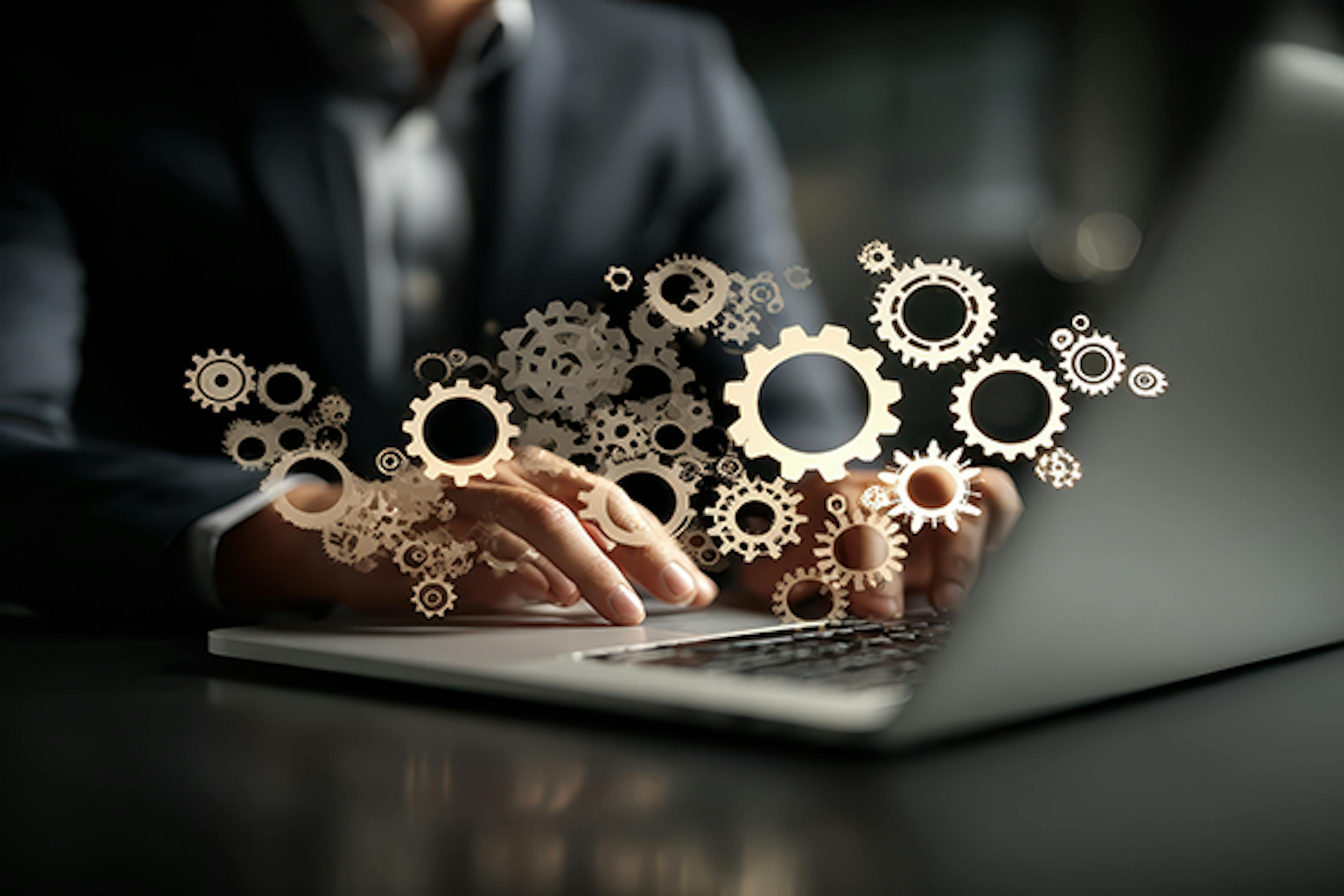 AI powered automation for business process and workflow. Many gear icons. Businessman using laptop computer to manage intelligent process automation technology