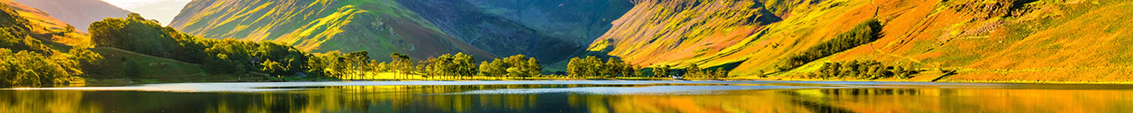 A range of hills reflected in a lake on a sunny day