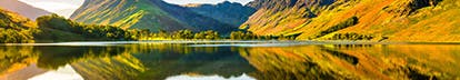 A range of hills reflected in a lake on a sunny day