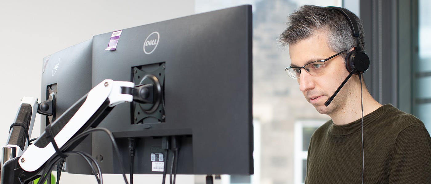 Man coding using two screens