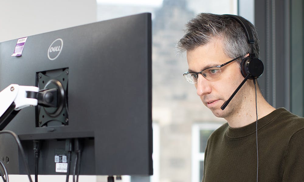 Man coding using two screens