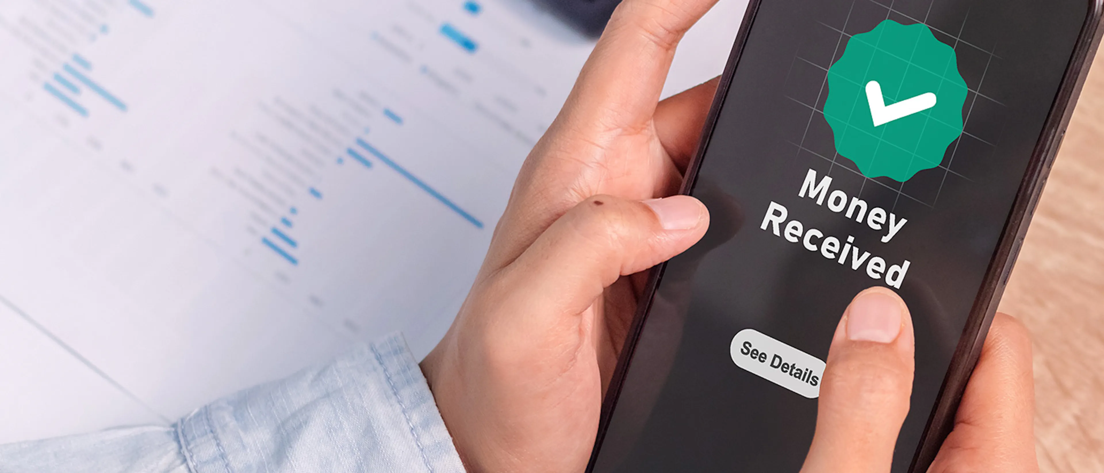 Person holding a phone saying Money Received on the screen