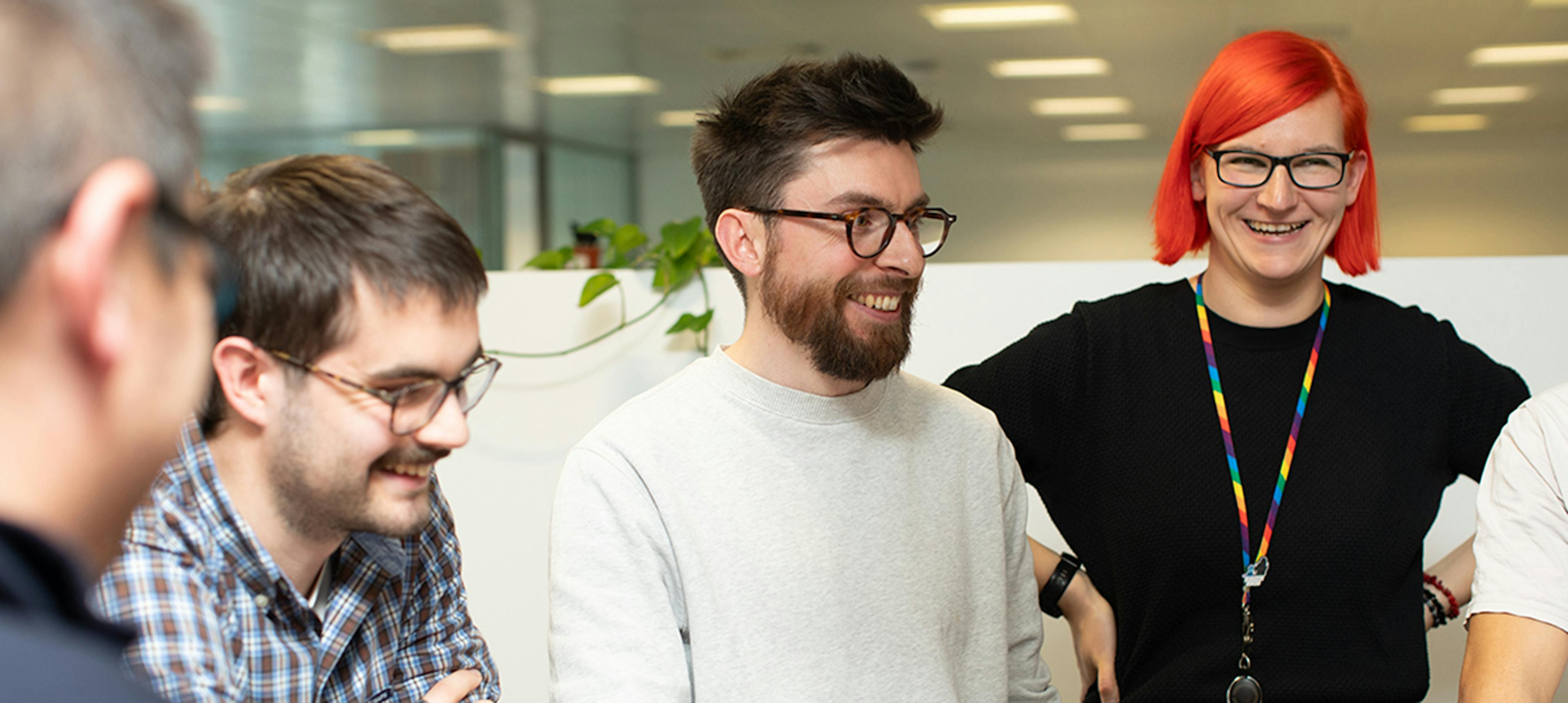 4 colleagues around a table smiling
