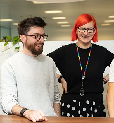 4 colleagues around a table smiling