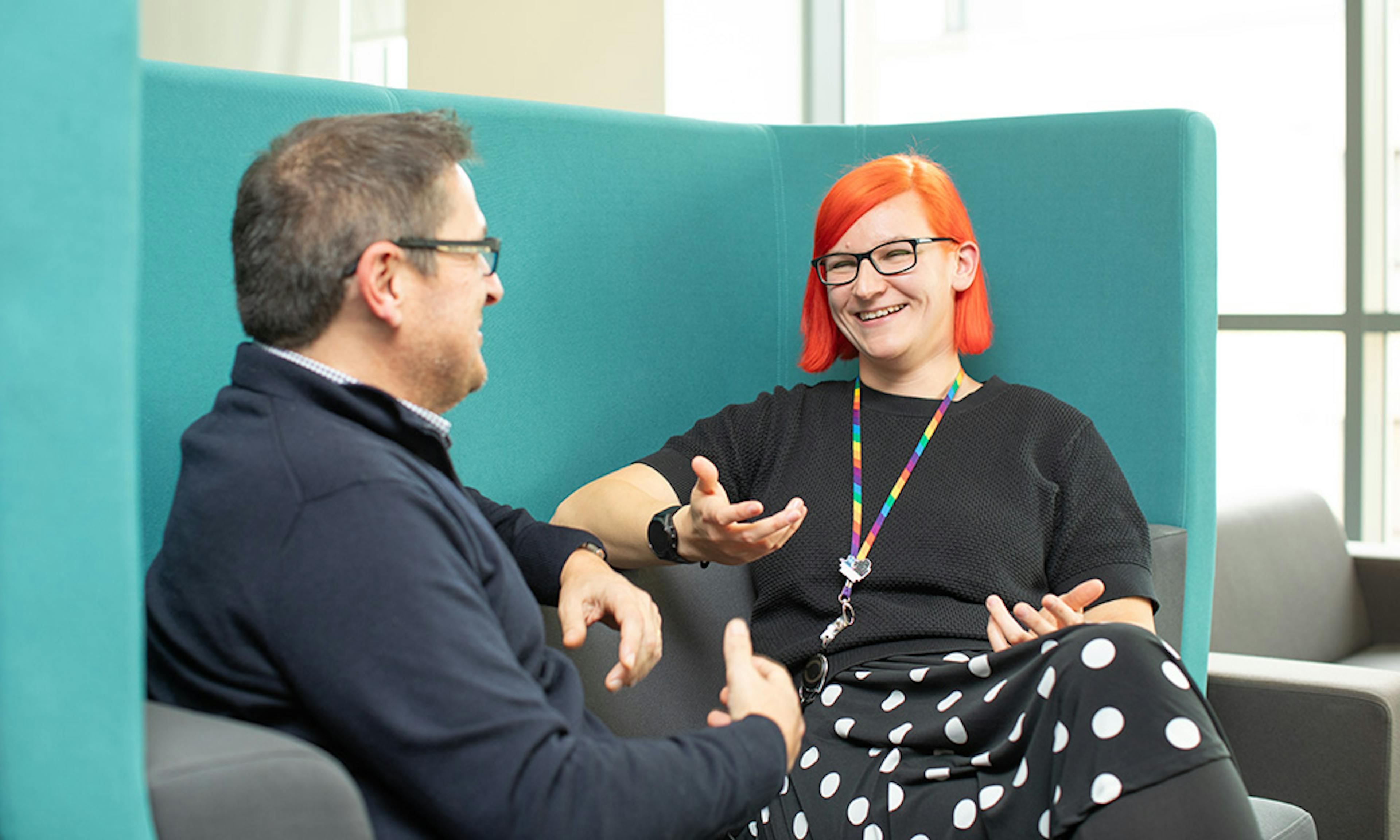 Two people in an informal meeting in an office setting