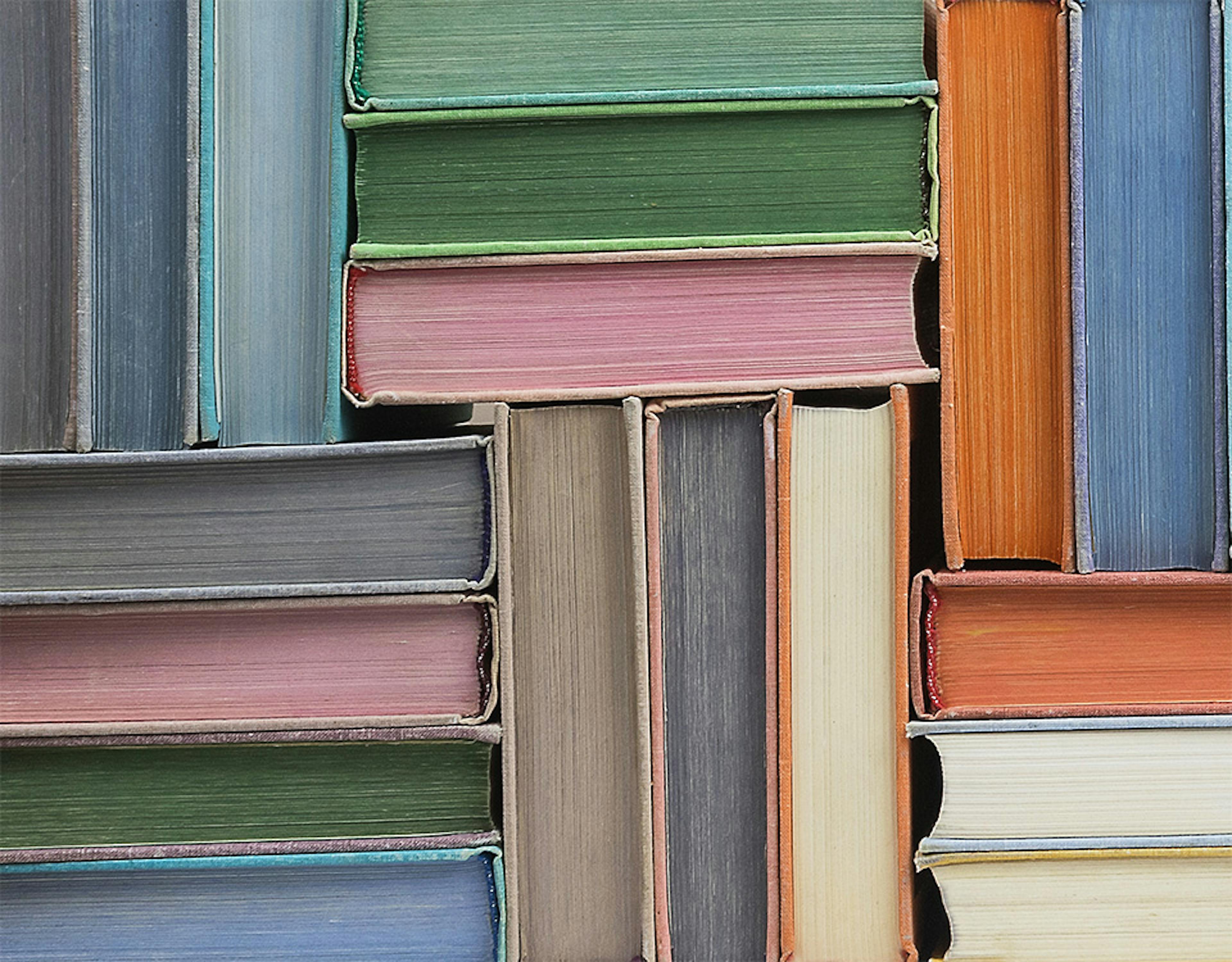 Colourful books stacked in a herringbone pattern