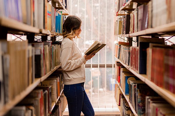 Woman reading a book in a library