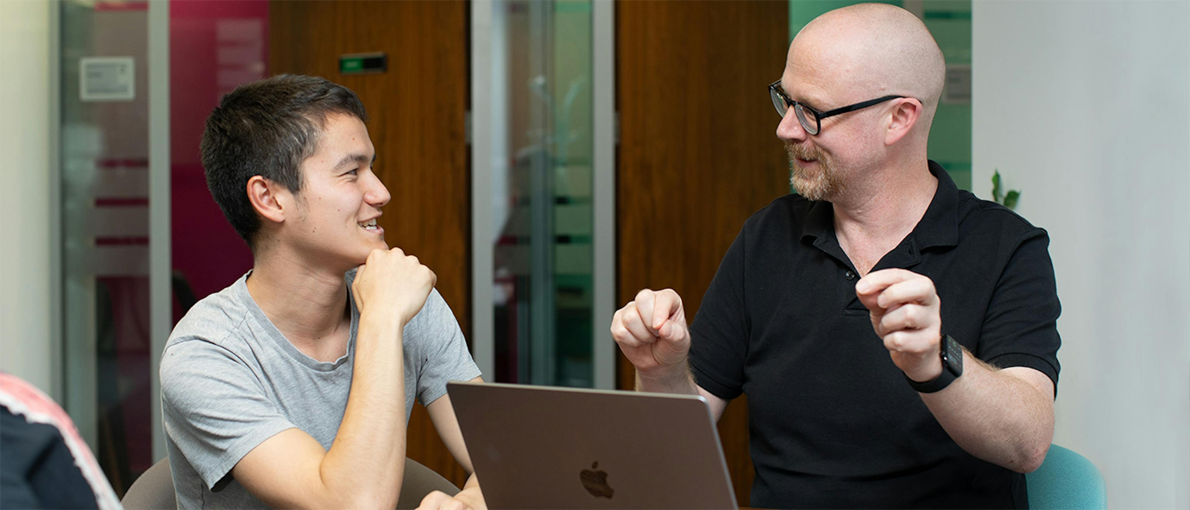 Two people in a meeting with a laptop