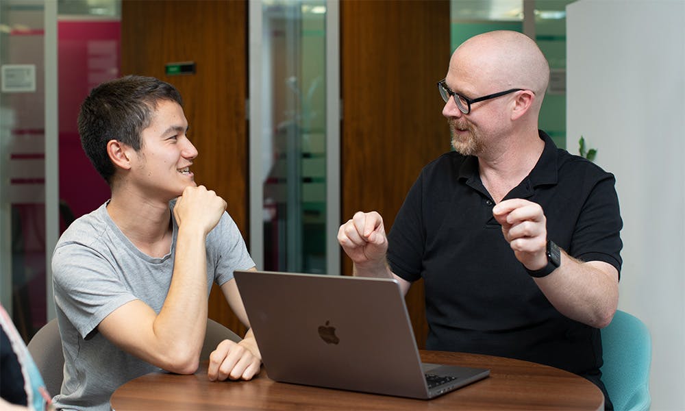 Two people in a meeting with a laptop