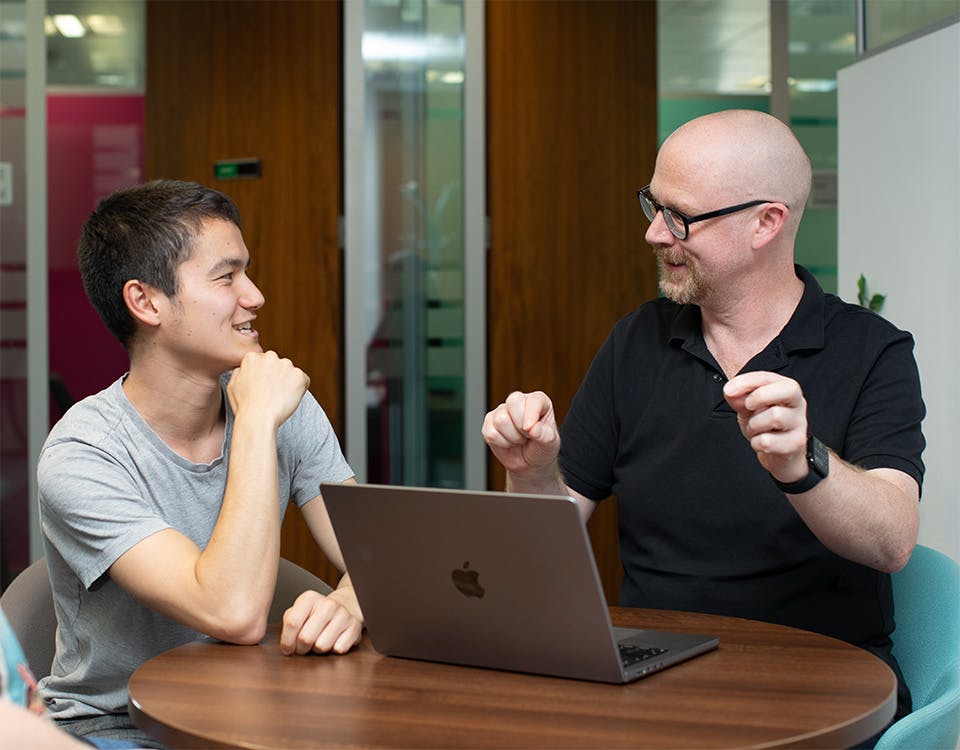 Two people in a meeting with a laptop