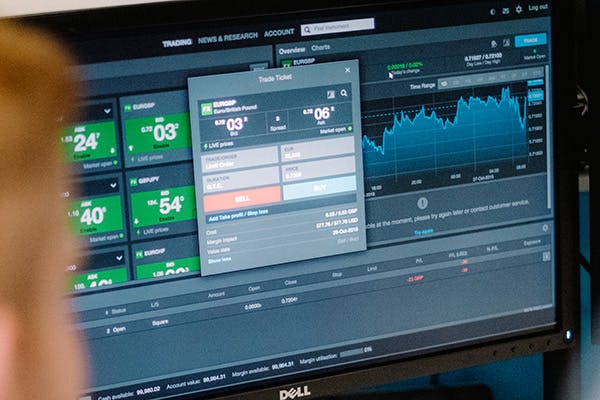 A person looking at a trading screen on a monitor
