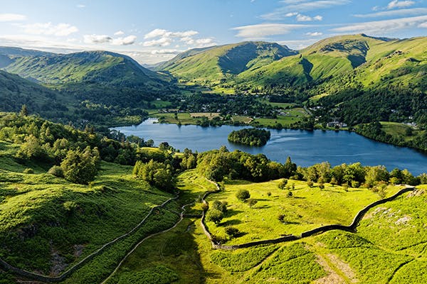 An aerial view of a lake surrounded by hills on a sunny day