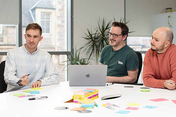 Three people collaborating in a workshop
