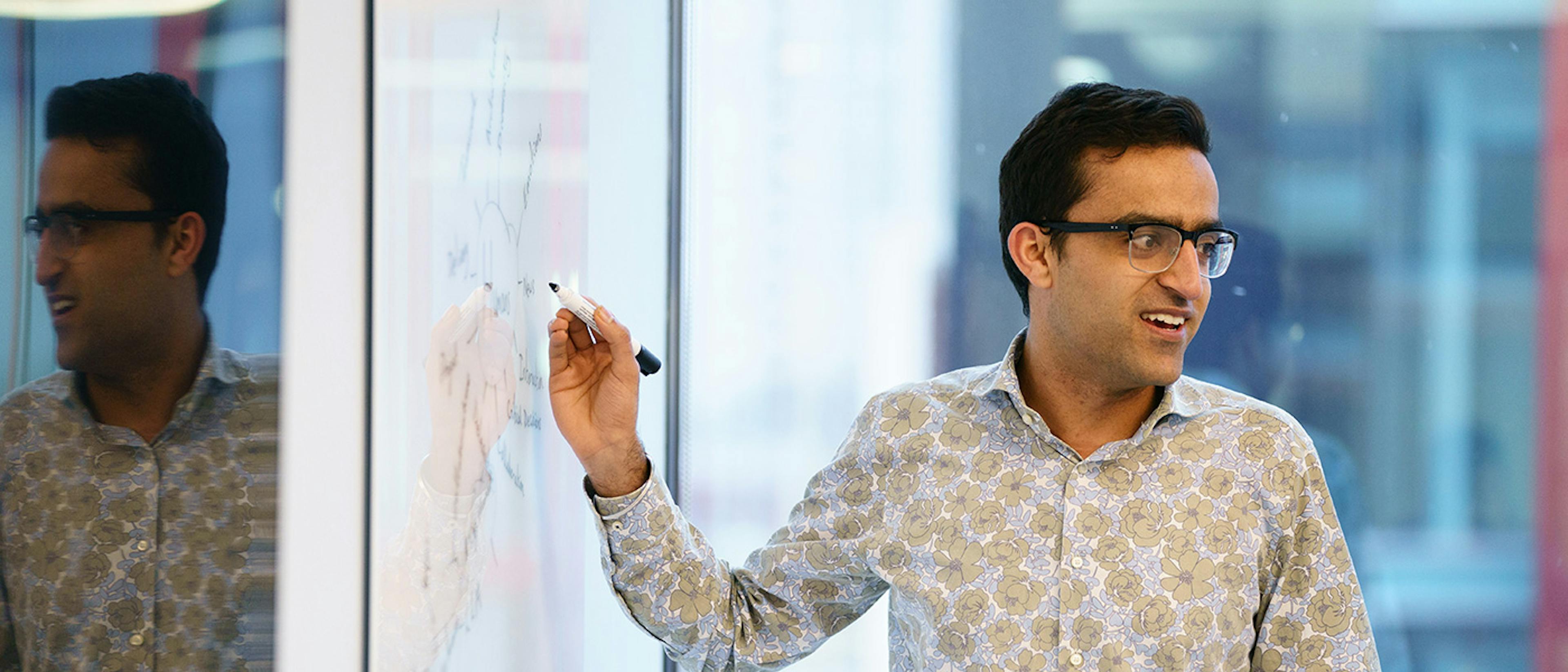 Man presenting at a whiteboard in an office