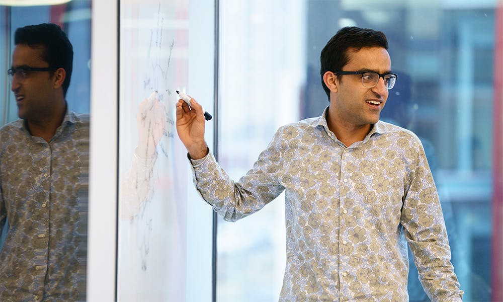 Man presenting at a whiteboard in an office