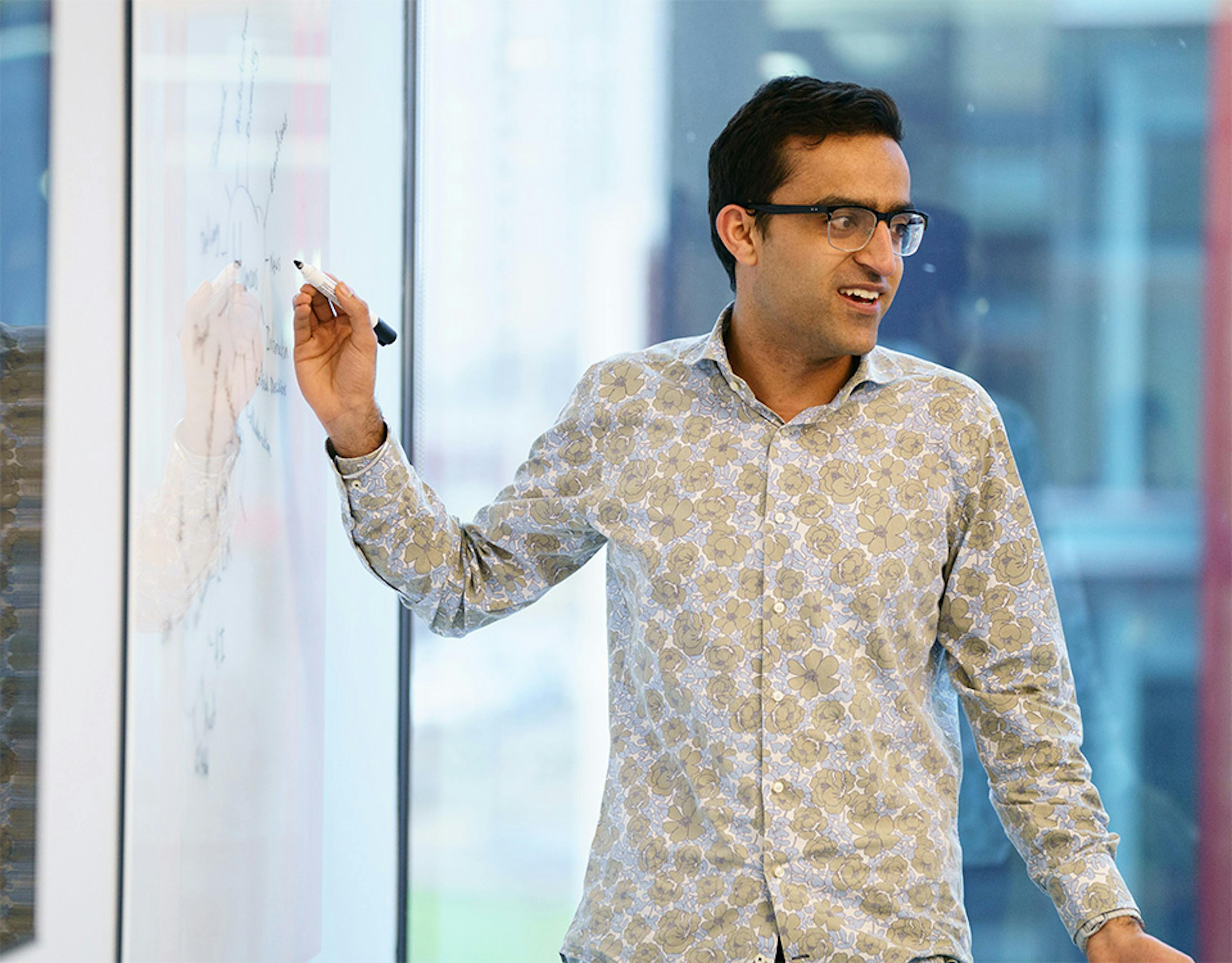 Man presenting at a whiteboard in an office