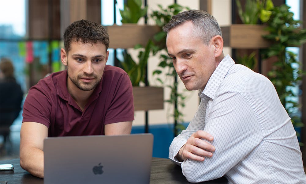 Two people looking at a laptop screen
