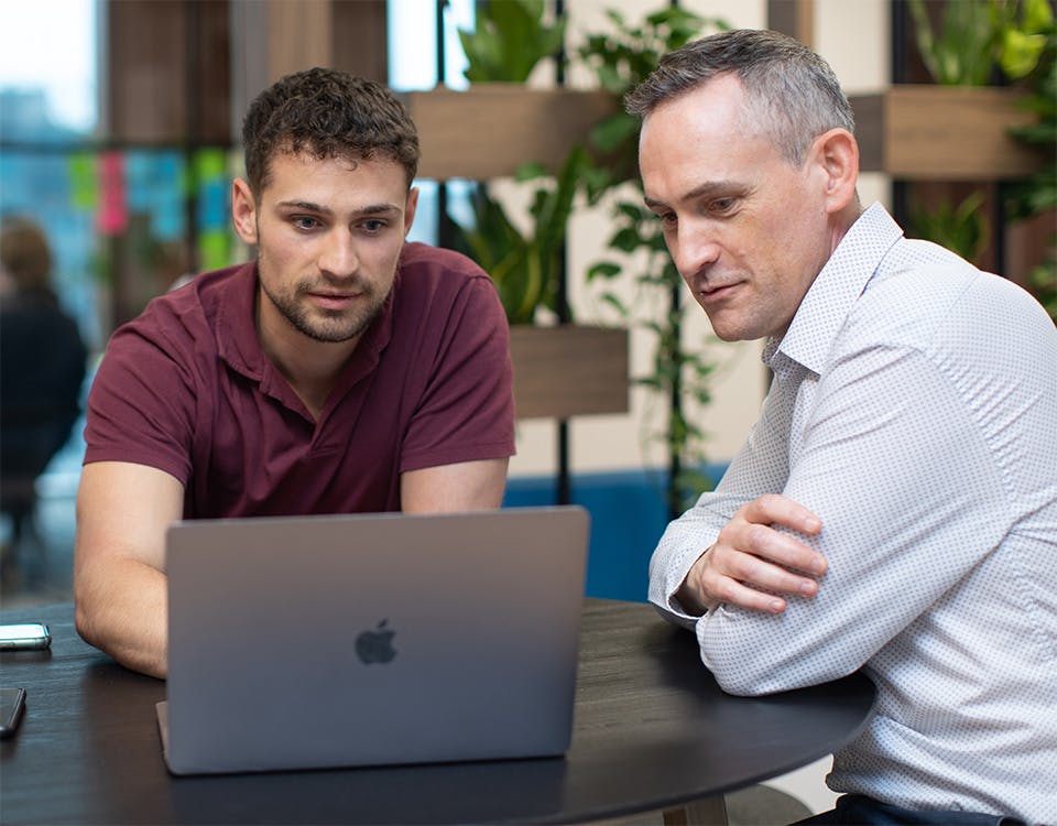 Two people looking at a laptop screen