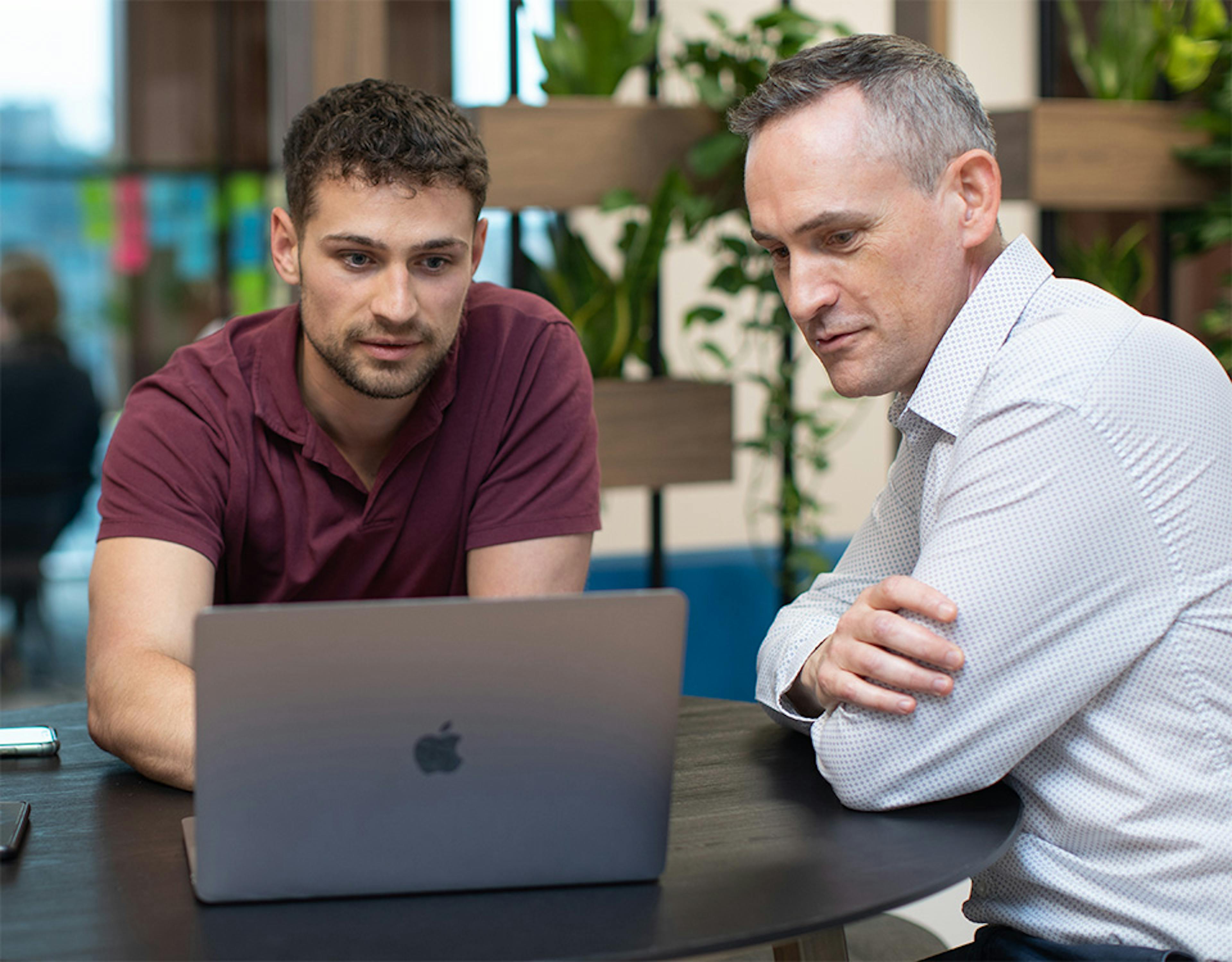 Two people looking at a laptop screen