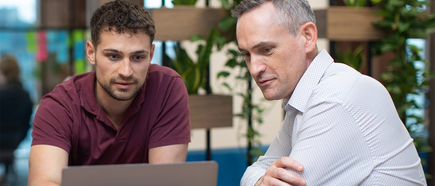 Two people looking at a laptop screen