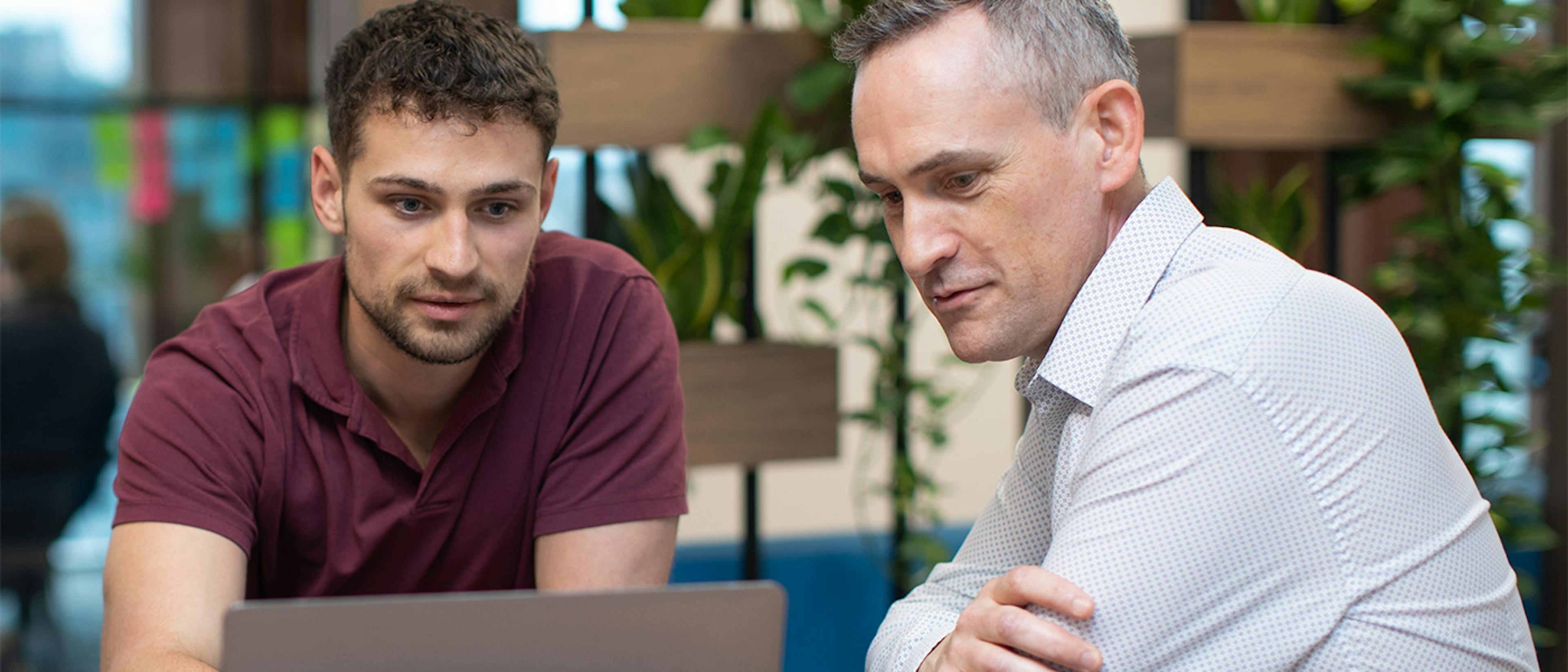 Two people looking at a laptop screen