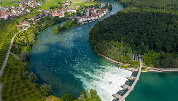 Rheinschleife bei Rheinau – an aerial view of a run-of-river power plant, with the river curving right and then left into the distance