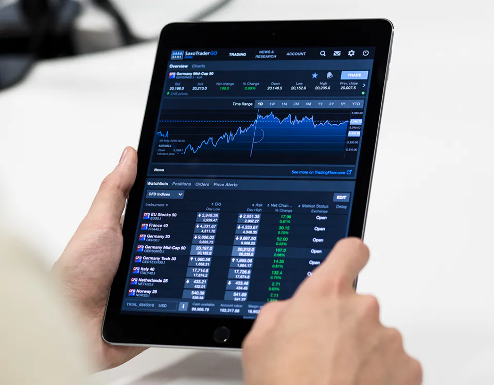 A person holding a tablet computer displaying a chart and a table