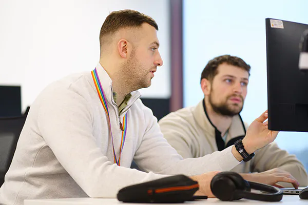 Two developers discussing some code on a screen