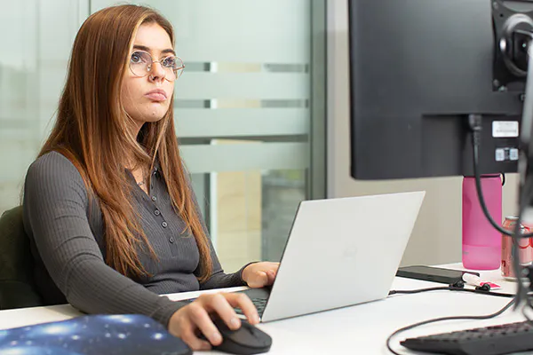 Developer working with two screens in an office setting