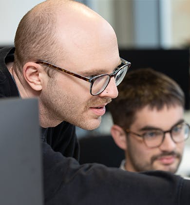 Two developers looking at computer monitor 