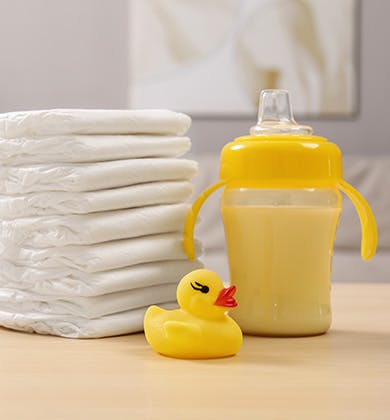 A table with towels, a rubber duck and a trainer cup
